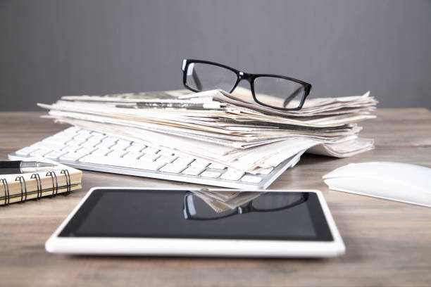 istock Newspapers, computer keyboard, eyeglasses on the wooden table. 1336868007