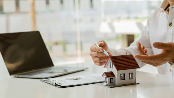 istock House plans with real estate agents and home purchase contract documents with calculator and laptop insurance concept or real estate loans 1336870813