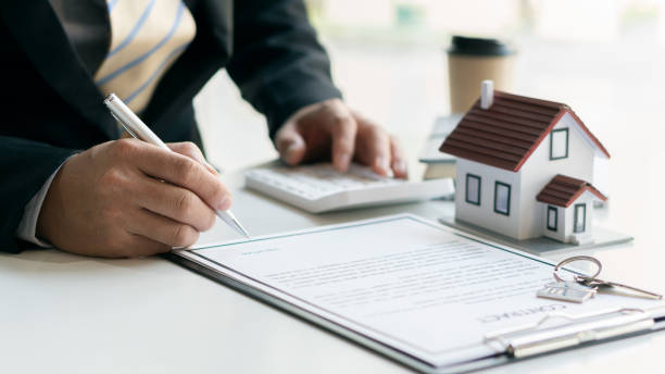 istock House plans with real estate agents and home purchase contract documents with calculator and laptop insurance concept or real estate loans 1336870837