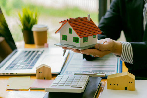 istock House plans with real estate agents and home purchase contract documents with calculator and laptop insurance concept or real estate loans 1336870902