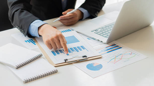 istock Businessman working on graph papers and laptops using income and expense calculators, accounts or financial auditors to make reports, calculations, home finance, investment, economy, savings or office insurance ideas. 1336871503