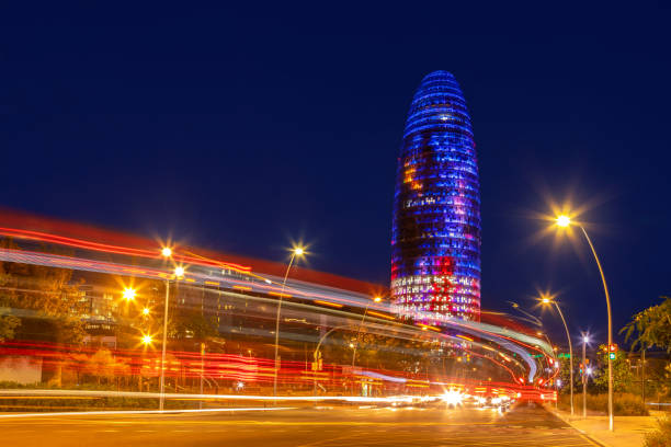 vue nocturne colorée de la tour glorias à barcelone - barcelone espagne photos et images de collection