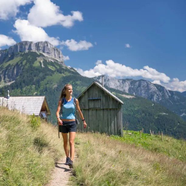 Beautiful Woman hiking through the Austrian Alps, Ausseerland, Salzkammergut, Altaussee, Austria. The Mountain Trisselwand and Loser in back.