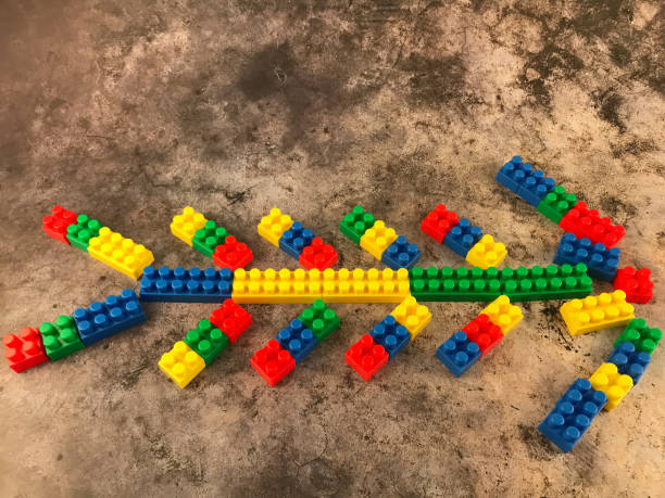 Fishbone -shaped by plastic toy blocks on grey background stock photo