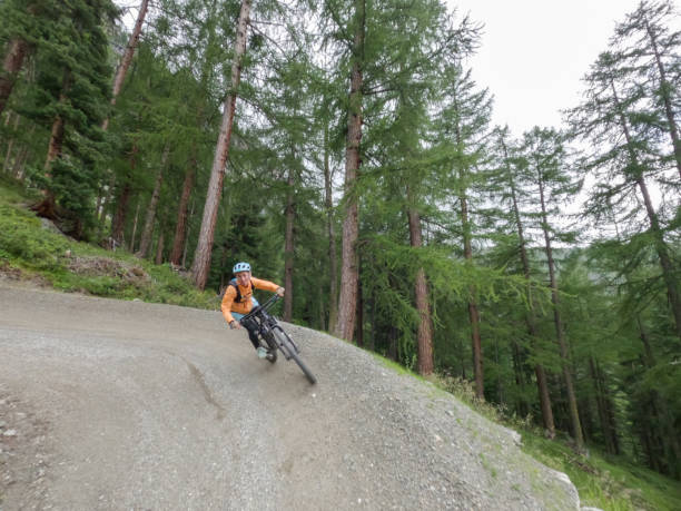 istock Female mountain biker rides along mountain trail. Front view 1336872833