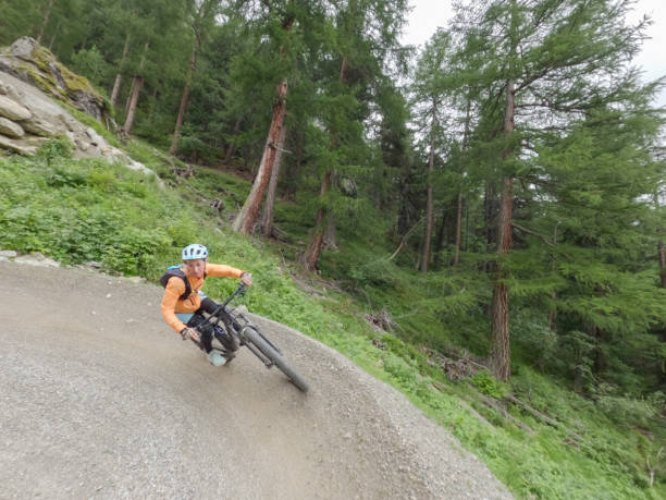 istock Female mountain biker rides along mountain trail. Front view 1336872835