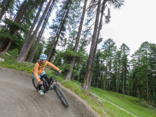 istock Female mountain biker rides along mountain trail. Front view 1336872841