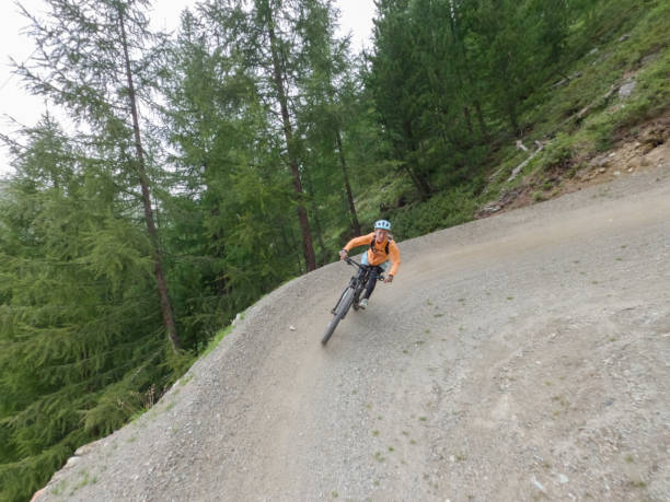 istock Female mountain biker rides along mountain trail. Front view 1336872866