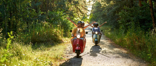 istock Happy young multiracial people driving scooter motorbikes 1336877143