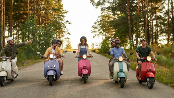 istock Happy young multiracial people riding retro scooters 1336878972