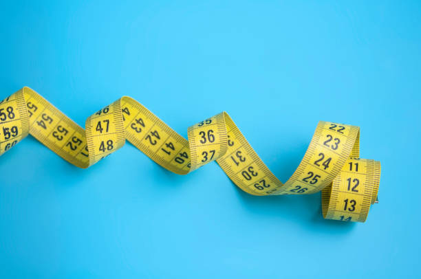 istock Yellow centimeter tape on blue background 1336879276