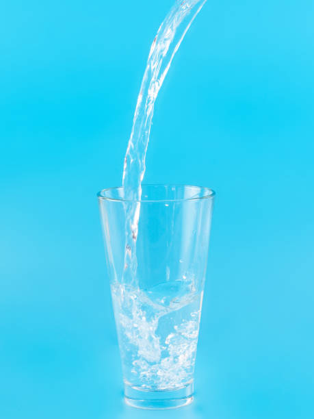 istock Glass with water aqua on blue background 1336879355