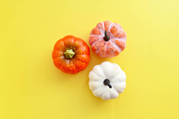 istock Pumpkins on yellow background. Autumn background, minimalistic concept 1336884601