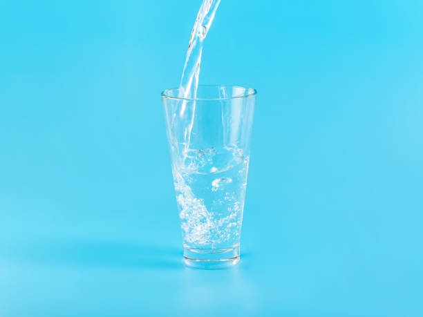 istock Glass with water aqua on blue background 1336884680