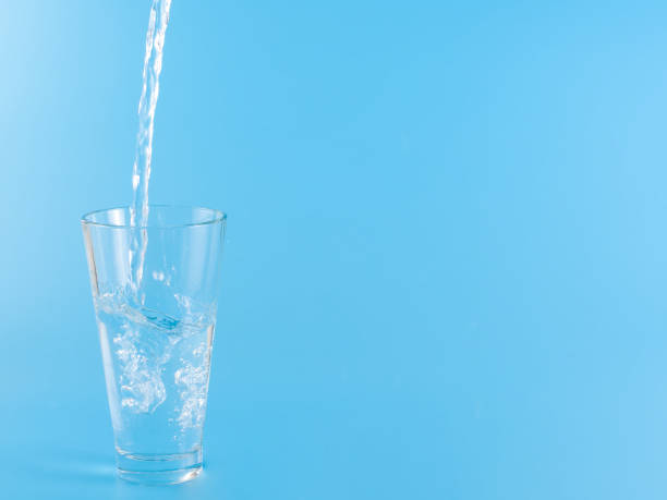 istock Glass with water aqua on blue background 1336885237