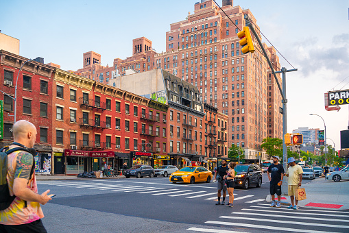New York City, New York, USA - July 15, 2021:  Street scene from Chelsea neighborhood in Manhattan of intersection with people, buildings and cars.