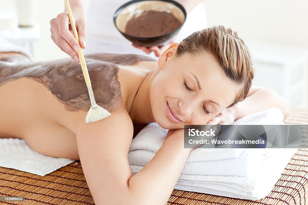 Mujer tranquila disfrutando de un tratamiento de barro de la piel - Foto de stock de Vista posterior libre de derechos