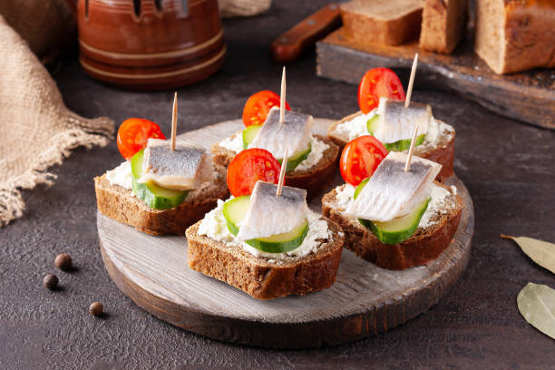 istock herring sandwiches on wooden board on brown stone 1336890044