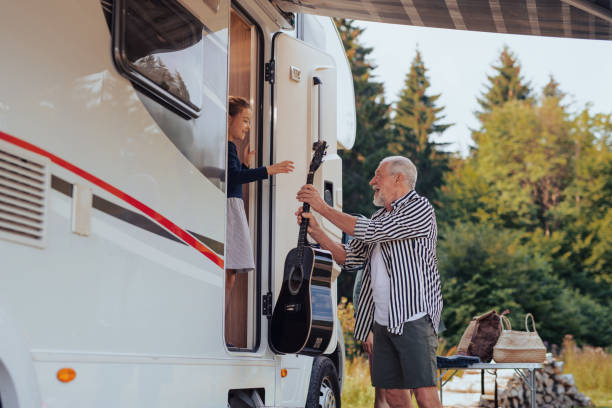 istock Multi-generation family unpacking and talking by car, caravan holiday trip. 1336890125