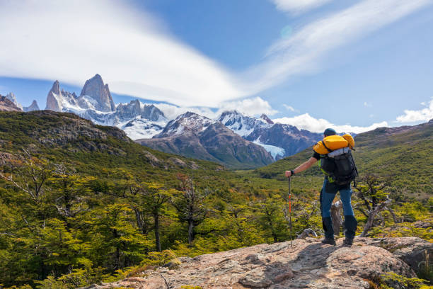 uomo con zaino in piedi sulla roccia con vista sul monte fitz roy in patagonia - provincia di santa cruz argentina foto e immagini stock