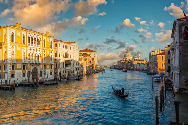 View of Venice's Grand Canal A gondolier paddles towards the sunset in Venice's Grand Canal venice italy stock pictures, royalty-free photos & images