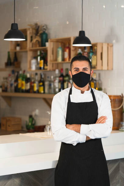istock Chef posing wearing uniform, protective mask and apron in restaurant. 1336896300