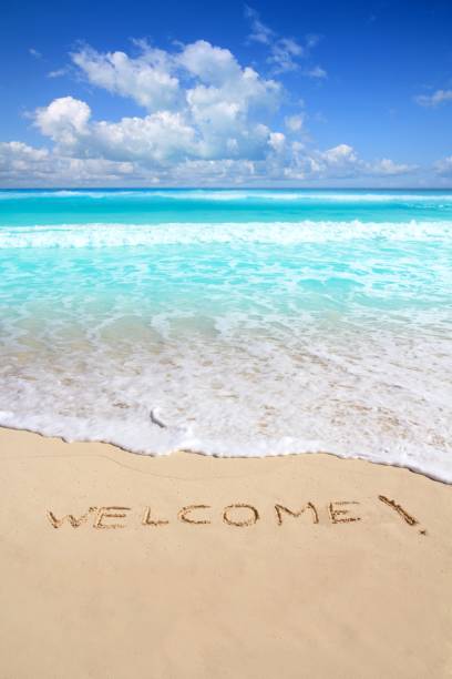 istock greetings welcome beach spell written on sand 1336896468