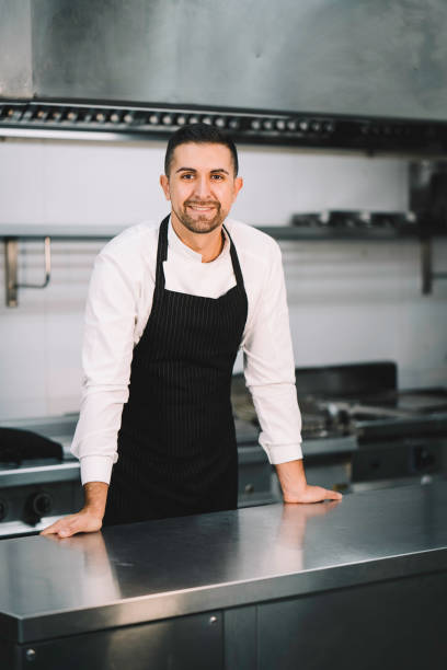 istock Chef posing wearing uniform and apron  in restaurant kitchen 1336896478