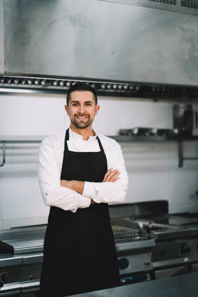 istock Chef posing wearing uniform and apron  in restaurant kitchen 1336896484