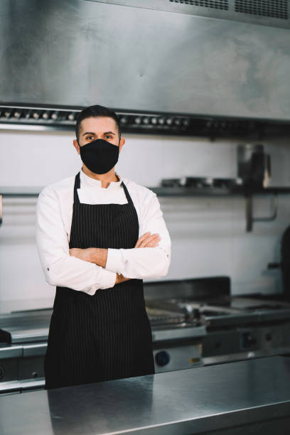 istock Chef posing wearing uniform, protective mask and apron  in restaurant kitchen 1336896517