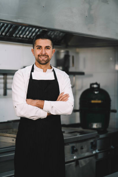 istock Chef posing wearing uniform and apron  in restaurant kitchen 1336896633