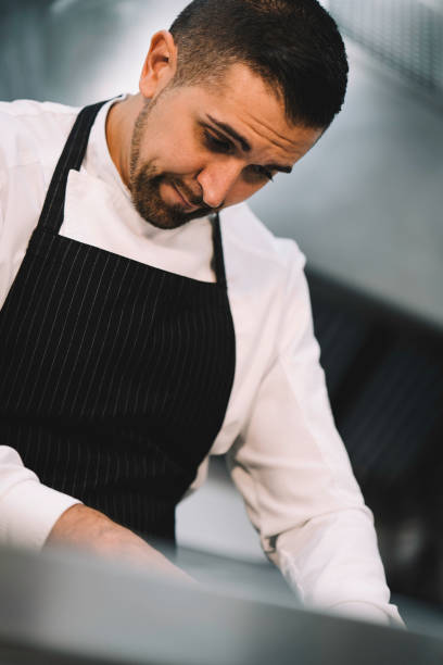 istock Professional chef slicing onions over a green board in the restaurant kitchen 1336896752
