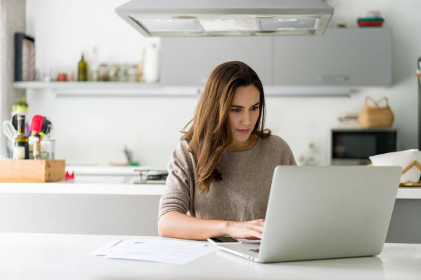 istock Woman working on her laptop computer while telecommuting from home 1336896886