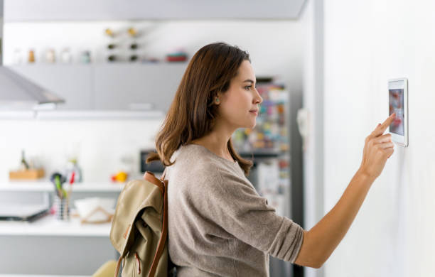 istock Woman leaving her house and locking the door using a home automation system 1336896892