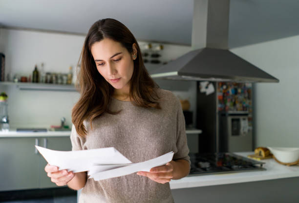 istock Pregnant woman at home checking her mail 1336896893