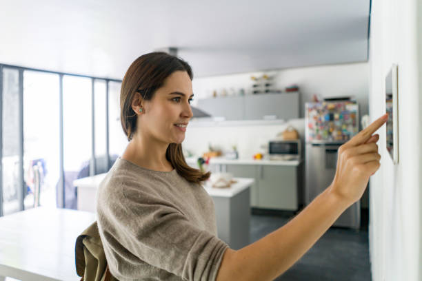 istock Woman locking the door of her house using a smart home security system 1336896894