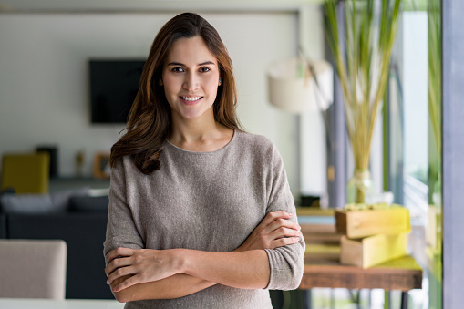 Portrait of a beautiful Latin American pregnant woman at home and looking at the camera smiling