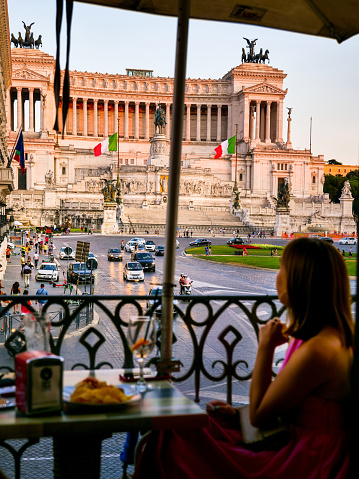 Rome, Italy, July 22 -- A tourist admires the artistic and architectural beauties of Piazza Venezia and the National Monument of the Altare della Patria illuminated by a delicate sunset light, in the historic heart of Rome. The Altare della Patria, or Vittoriano, was built in 1885 in neoclassical style in honor of the first King of Italy, Vittorio Emanuele II, along the north side of the Capitoline Hill and the Roman Forum. Inside is the Tomb of the Unknown Soldier, a War Memorial dedicated to all the Italian soldiers who died in the war. The Altare della Patria is the scene of all the official Italian civic celebrations, in particular the Republic Day on June 2 and the Liberation Day on April 25. In 1980 the historic center of Rome was declared a World Heritage Site by Unesco. Image in high definition format.