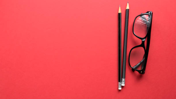 istock Pencil and glasses on a red background with copy space. 1336901870