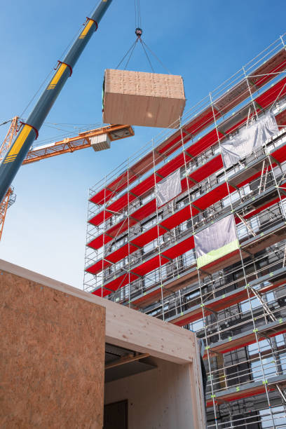 istock Crane lifting a wooden building module to its position in the structure. 1336902968