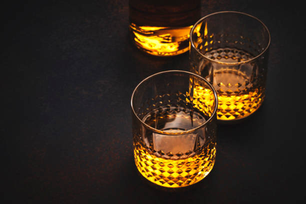 amerikanischer bourbon whisky in gläsern und flasche, schwarzer hintergrund mit negativem raum - cereal bar stock-fotos und bilder