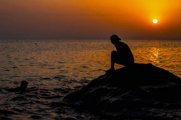 istock Girl on stone and boy in water 1336909778