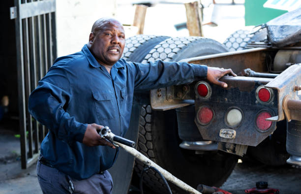 istock African-American man repairing semi-truck, using jack 1336909958