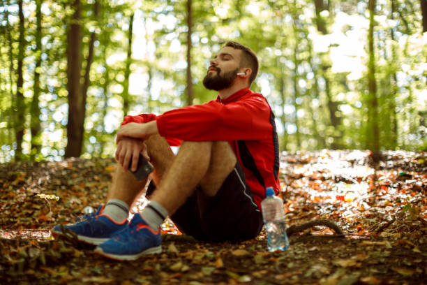 istock Young man with bluetooth headphones resting in forest 1336911099
