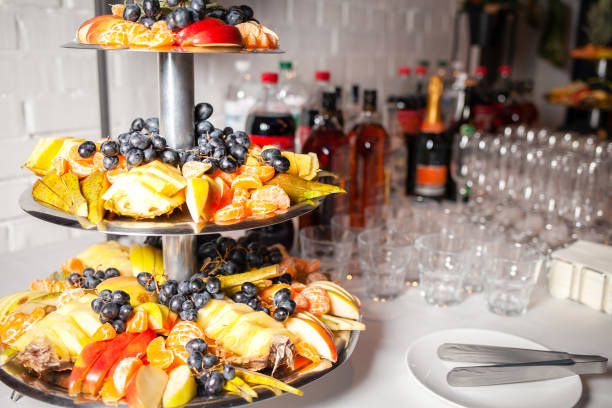 Mixed fruit arrangement on multiple tiers of trays. Fruits shown include grape, watermelon, pineapple, melon, lime, and others