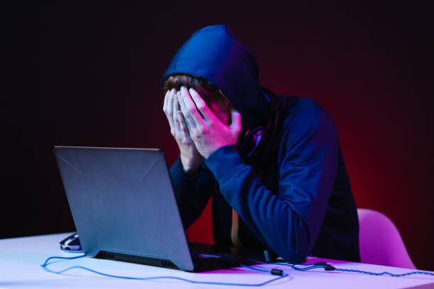 istock Professional hacker with laptop sitting at table on dark background 1336918479