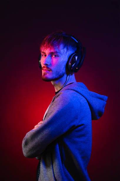 Portrait of man with headphones in neon lights stock photo