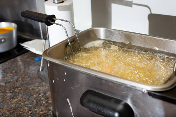 bubbling oil A view of food bubbling in oil inside a consumer fryer machine. deep fryer stock pictures, royalty-free photos & images