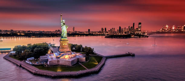 vue du coucher de soleil sur la statue de la liberté - new york city panoramic statue of liberty skyline photos et images de collection