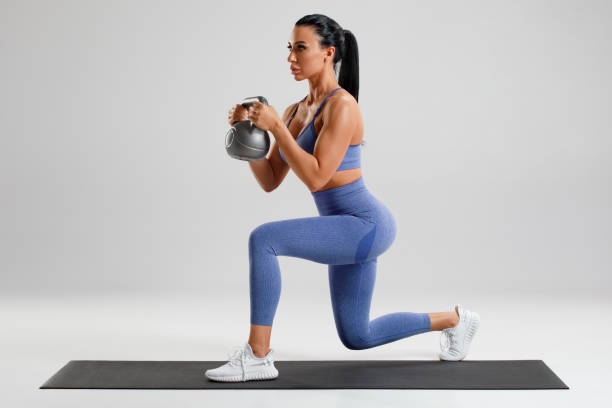 Fitness woman doing lunges exercises with kettlebell ripl fitness